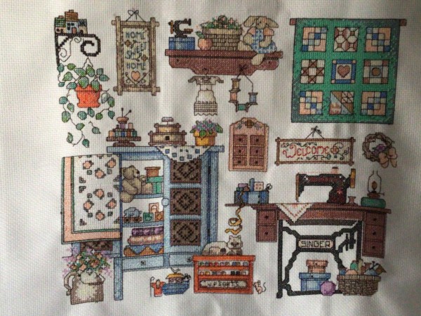 machine cross-stitched sample on aida fabric of a rustic sewing room scene