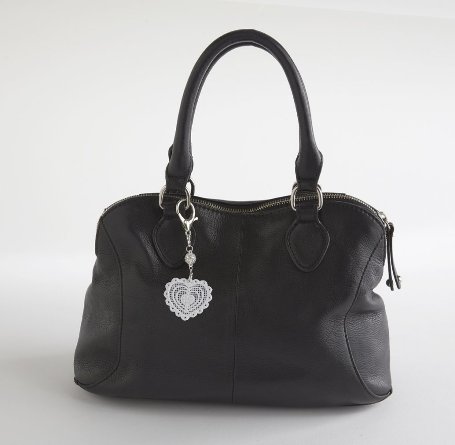 Black handbag with white heart shaped lace charm attached