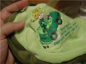 Embroidered design on belly of turtle backpack.